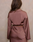 Kleding set van korte blouse en asymmetrische rok in roze/brons. Een chique en modieuze combinatie voor een opvallende uitstraling.