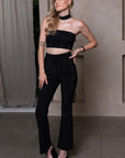 Chique kledingset met high-waisted flared pants, strapless top en choker, allemaal versierd met elegante decoratieve stenen.