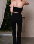 Chique kledingset met high-waisted flared pants, strapless top en choker, allemaal versierd met elegante decoratieve stenen.