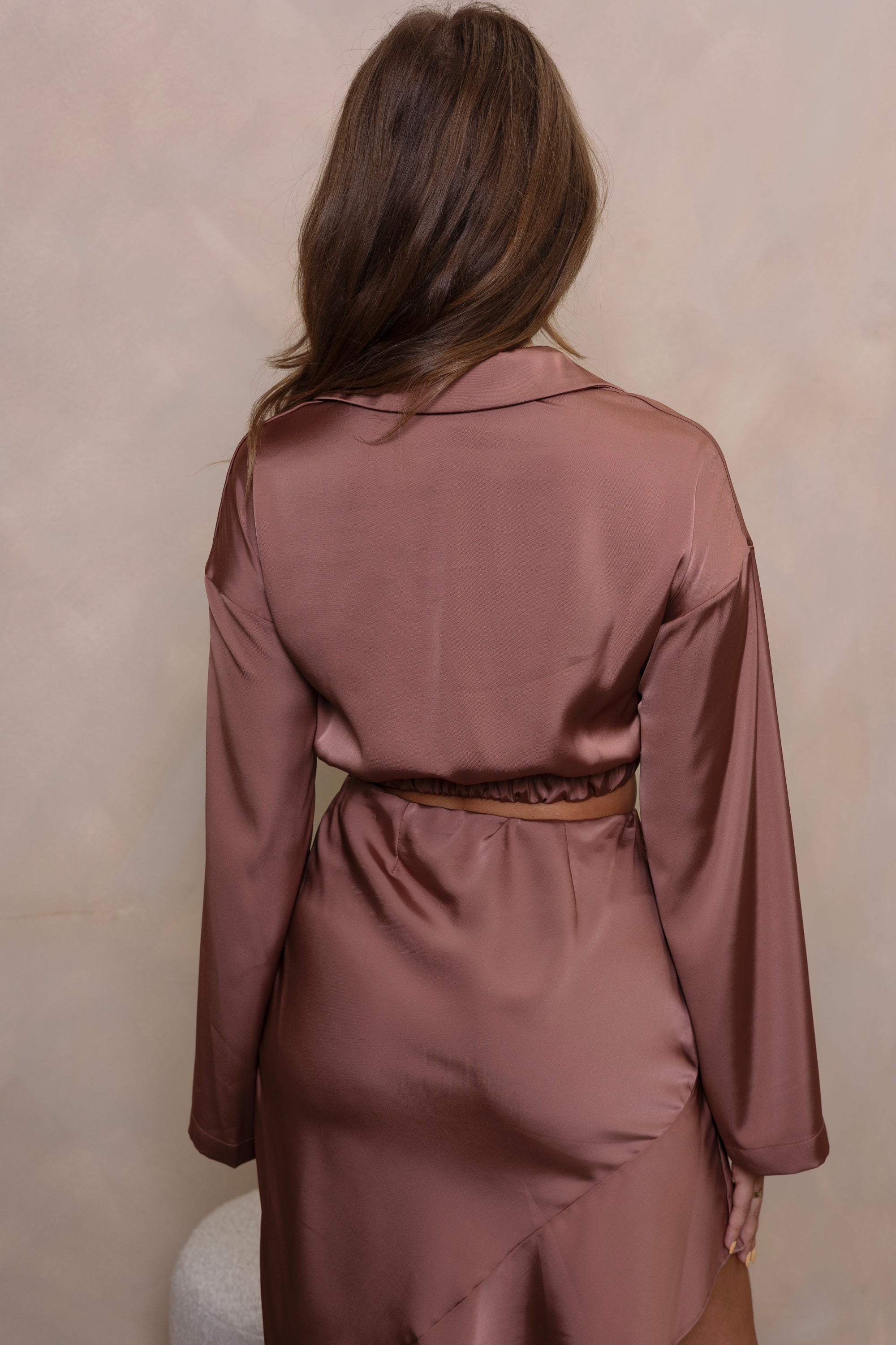 Kleding set van korte blouse en asymmetrische rok in roze/brons. Een chique en modieuze combinatie voor een opvallende uitstraling.